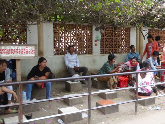 Vor den Eingängen sitzen Frauen und warten