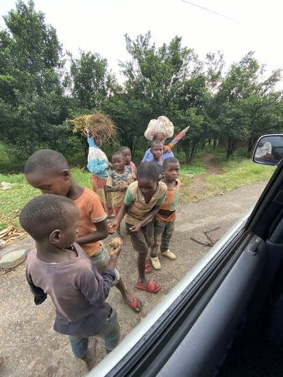 Evrard verteilt etwas von seinem Obst an die Kinder. Egal wo wir anhalten: es dauert nicht lange und die Kinder kommen herbeigelaufen.