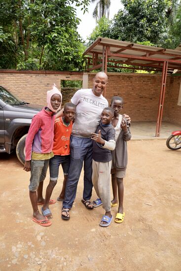 Es hängen sich gleich mehrer Kinder an Evrard. Sie wollen unbedingt das Auto reinigen und waschen. Evrard erteilt den Auftrag hierzu.